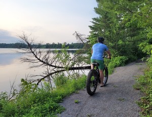 <strong>Person biking on trail with view of the River</strong>